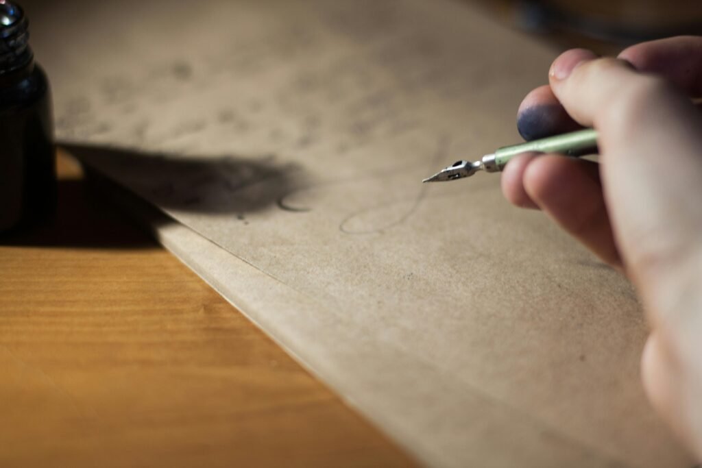 pexels-photo-211291-211291 Close-up of a hand writing with a fountain pen on vintage paper, capturing the art of calligraphy.